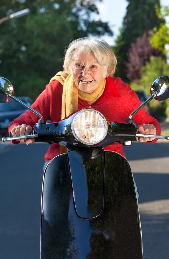 Senior woman speeding on a scooter stock image Senior woman speeding on a scooter stock image