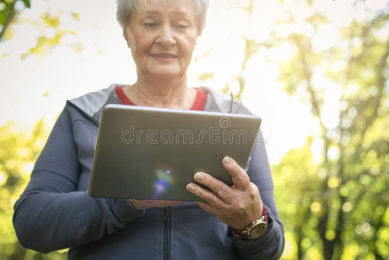 Senior woman in sports clothing after exercise using di royalty free stock photography Senior woman in sports clothing after exercise using di royalty free stock photography