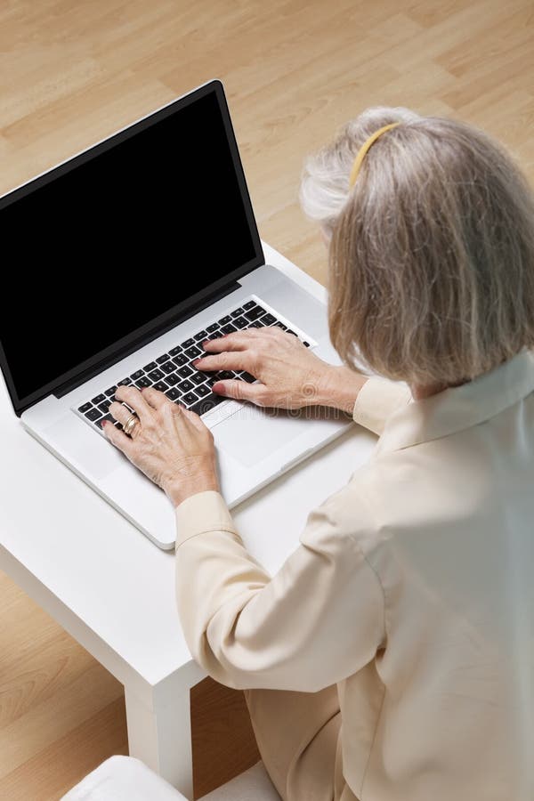 Senior woman surfing the net on laptop at home stock photography Senior woman surfing the net on laptop at home stock photography
