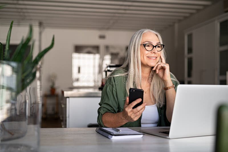 Senior woman using laptop and smartphone