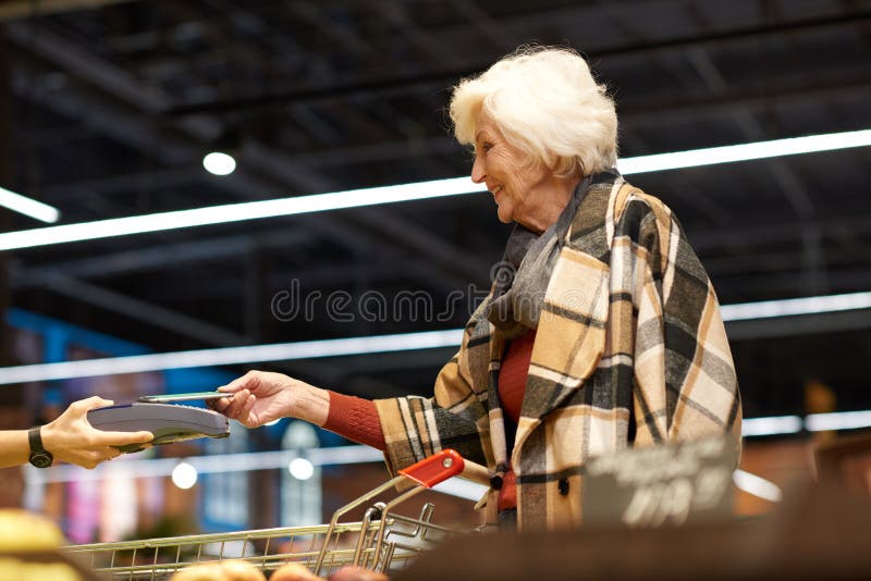 Senior Woman Using NFS in Supermarket stock images Senior Woman Using NFS in Supermarket stock images
