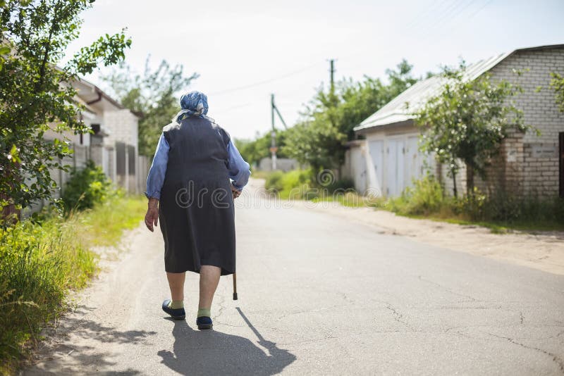 Senior woman walking down street.