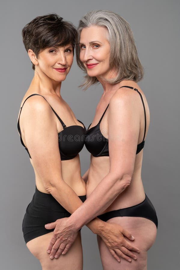 Senior women in black bra and panties standing - Stock Photo