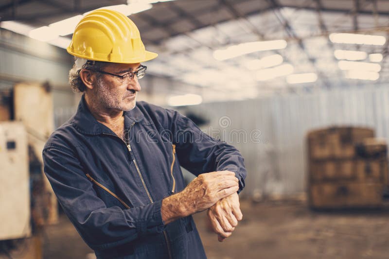 Timpul de lucru al inginerului senior verifică căutarea ceasului de mână pentru lucrul în intervale precise de timp royalty free stock photography