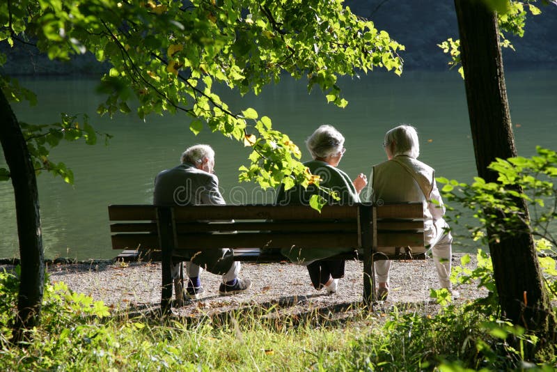 Alcuni anziani seduti su una panchina, avere una buona conversazione.