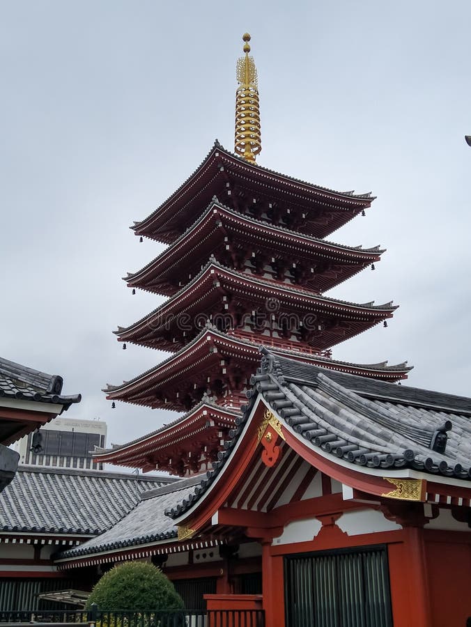 TOKYO, JAPAN - APRIL 3, 2018: Senso-ji or Asakusa is an ancient Buddhist temple. A large red pagoda stands in the distance. TOKYO, JAPAN - APRIL 3, 2018: Senso-ji or Asakusa is an ancient Buddhist temple. A large red pagoda stands in the distance