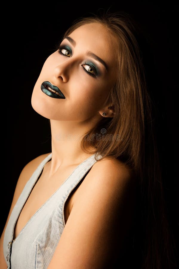 Sensual young model with perfect skin and creative metallic green makeup. Closeup portrait at studio on a dark background royalty free stock photos Sensual young model with perfect skin and creative metallic green makeup. Closeup portrait at studio on a dark background royalty free stock photos