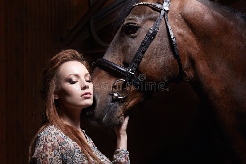 Sensual girl and horse in haysloft