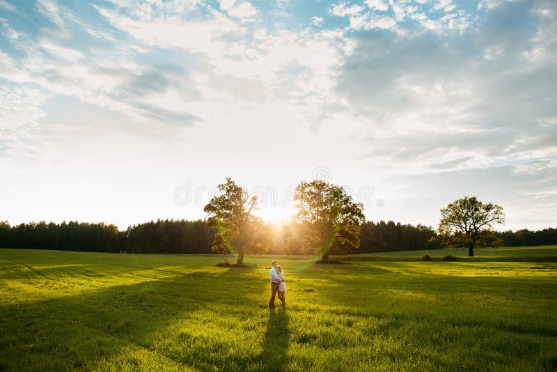 Sensual outdoor portrait of young stylish couple posing in field