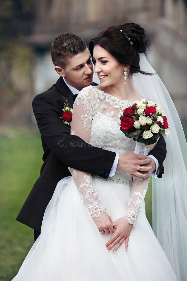 Sensual romantic groom hugging beautiful bride from behind with stock photography Sensual romantic groom hugging beautiful bride from behind with stock photography
