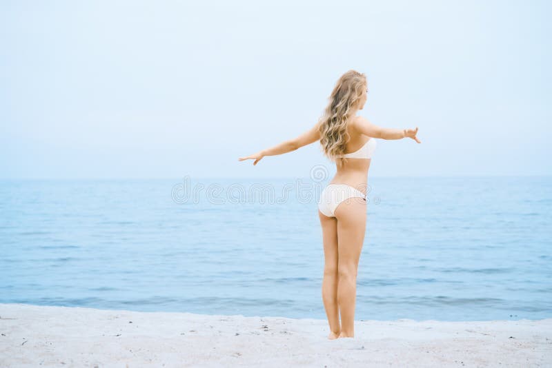 Sensual, lady coated with white swimsuit on the beach