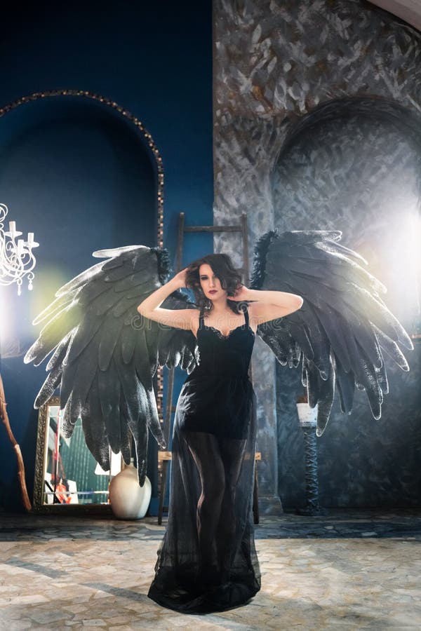 Sensual woman in black angel costume stock photo