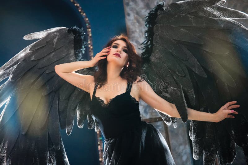 Sensual woman in black angel costume royalty free stock photography