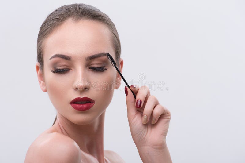 Sensueel meisje die haar brows zorgvuldig kammen royalty-vrije stock afbeelding Sensueel meisje die haar brows zorgvuldig kammen royalty-vrije stock afbeelding