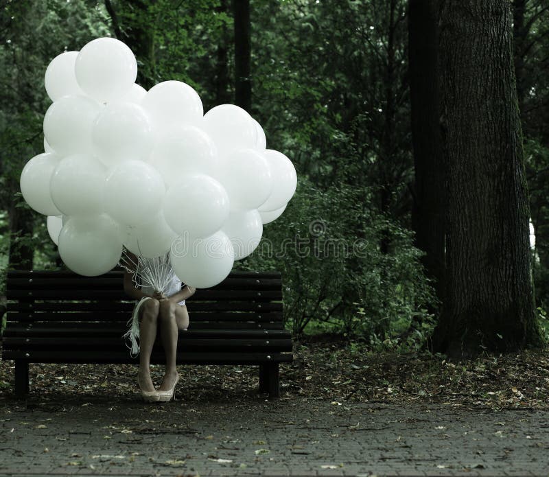 Sentimentality. Nostalgia. Lonely Woman with Air Balloons sitting on Bench in the Park stock photo Sentimentality. Nostalgia. Lonely Woman with Air Balloons sitting on Bench in the Park stock photo
