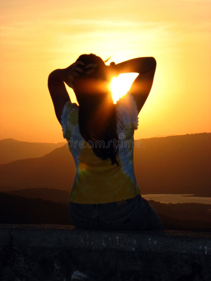 A woman relaxing and feeling the warmth of the setting sun. A woman relaxing and feeling the warmth of the setting sun