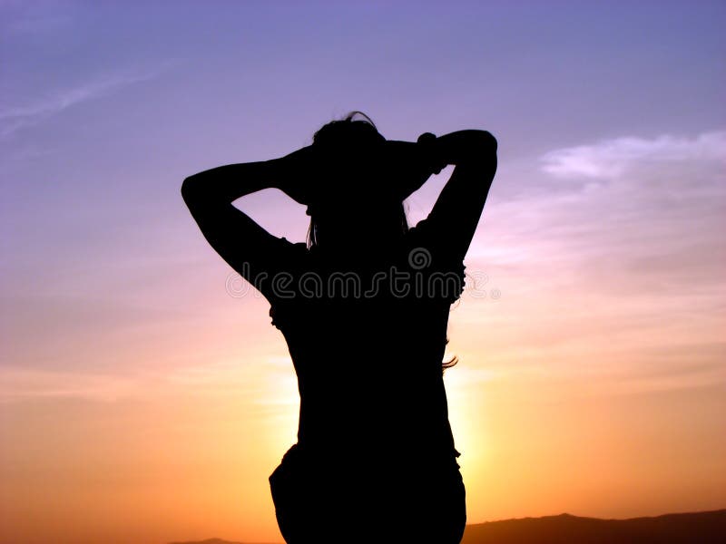 A woman relaxing and feeling the warmth of the setting sun. A woman relaxing and feeling the warmth of the setting sun