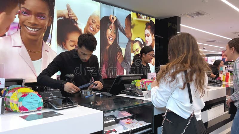 Sephora ένα κορίτσι αγοράζει πολλά καλλυντικά αποθηκεύοντας τη χαρά της ευτυχίας στο ταμείο πληρώνει με μια κάρτα μια όμορφη κάρτα