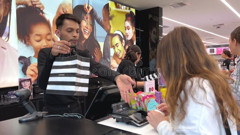 Sephora ένα κορίτσι αγοράζει πολλά καλλυντικά αποθηκεύοντας τη χαρά της ευτυχίας στο ταμείο πληρώνει με μια κάρτα μια όμορφη κάρτα