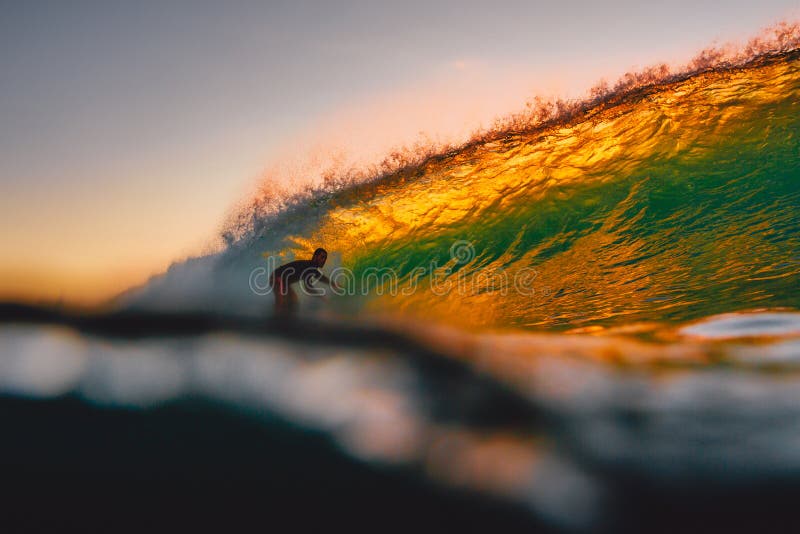 8 september, 2018 Bali, Indonesië Surferrit op vatgolf bij warme zonsondergang Het professionele surfen in oceaan, Bingin-strand stock foto 8 september, 2018 Bali, Indonesië Surferrit op vatgolf bij warme zonsondergang Het professionele surfen in oceaan, Bingin-strand stock foto