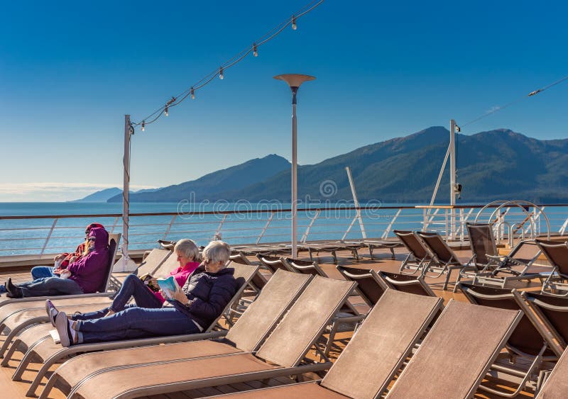 September 14, 2018 - Inside Passage, Alaska: Cruise passengers reading outdoors. royalty free stock photography September 14, 2018 - Inside Passage, Alaska: Cruise passengers reading outdoors. royalty free stock photography