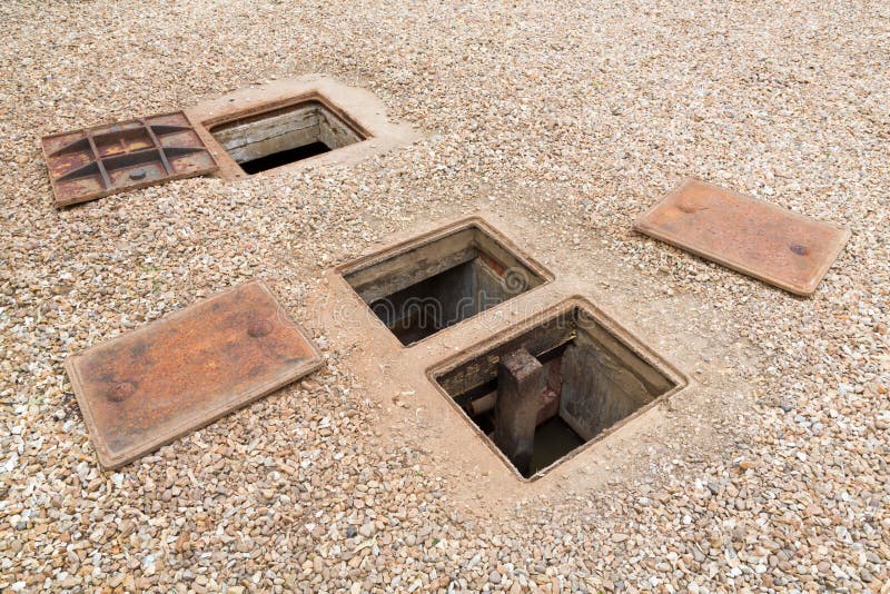 Septic tank or rainwater system with open manhole cover, UK. Inspecting an underground septic tank or rainwater system with open manhole cover, UK royalty free stock image Septic tank or rainwater system with open manhole cover, UK. Inspecting an underground septic tank or rainwater system with open manhole cover, UK royalty free stock image