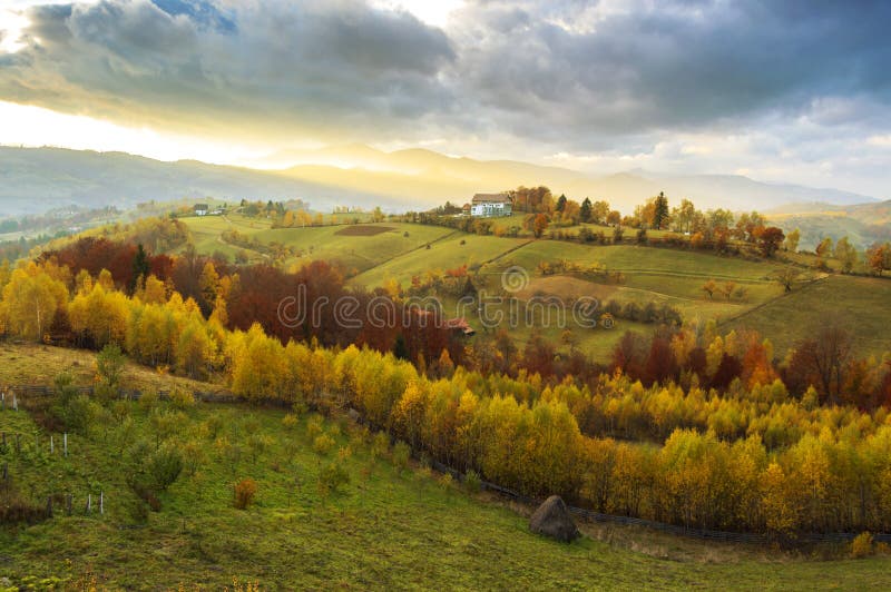 Sera calda di ottobre nella Transilvania Paesaggio magico di tramonto di autunno immagine stock libera da diritti Sera calda di ottobre nella Transilvania Paesaggio magico di tramonto di autunno immagine stock libera da diritti