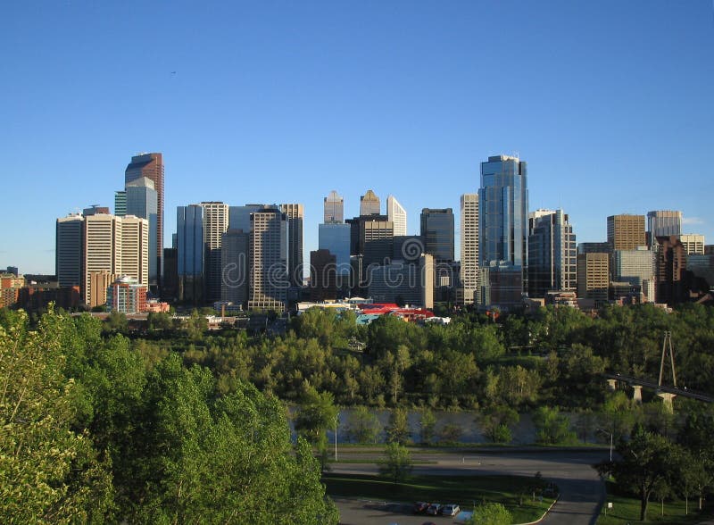 A view of the city from a hill in the evening. Plenty of trees and a river liven up this scene. A view of the city from a hill in the evening. Plenty of trees and a river liven up this scene.