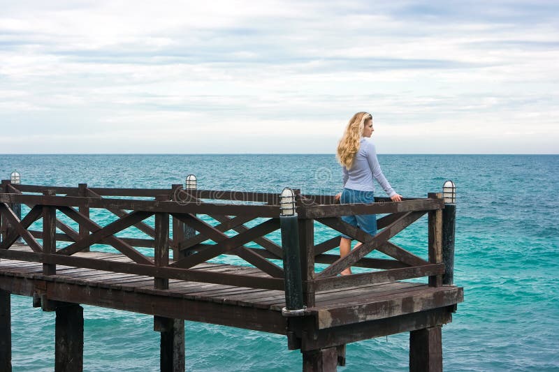 Cute girl standing on the wooden pier. Cute girl standing on the wooden pier