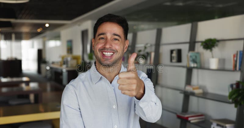 Serio joven empresario hispano posando para retrato de disparo en la cabeza almacen de video