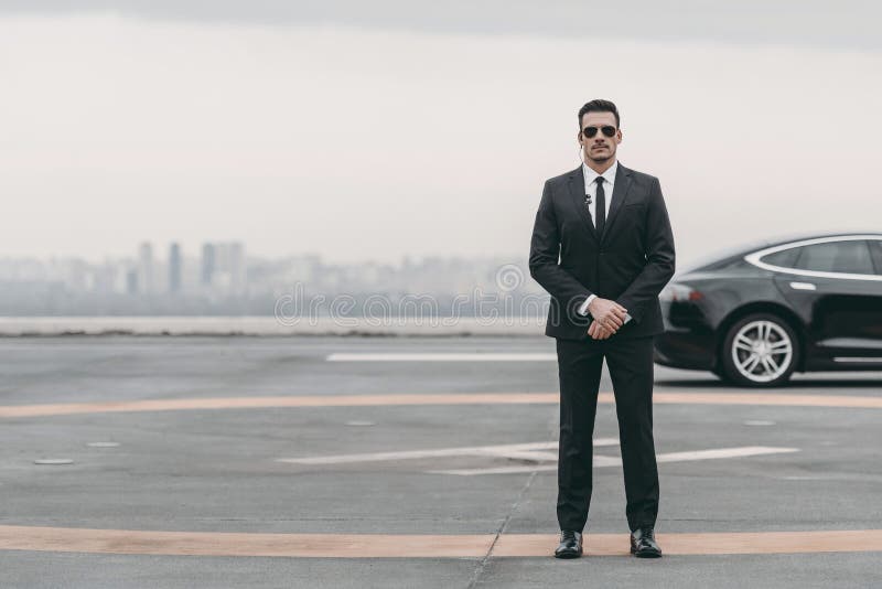 https://thumbs.dreamstime.com/b/serious-bodyguard-standing-sunglasses-security-earpiece-helipad-looking-camera-serious-bodyguard-standing-119789994.jpg