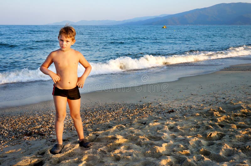 Serious boy posing by the sea