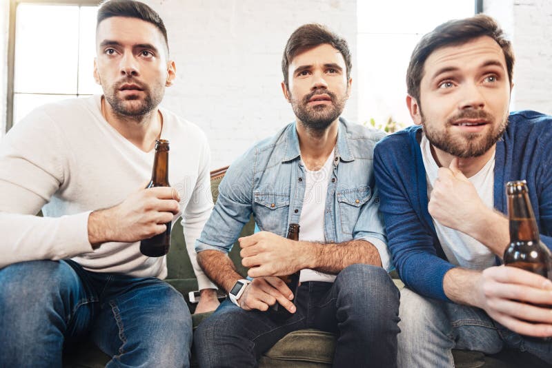 Serious brutal men watching sports games on TV royalty free stock image Serious brutal men watching sports games on TV royalty free stock image