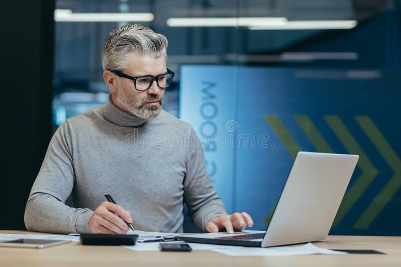 serious businessman behind paper work in office, gray-haired investor signing documents