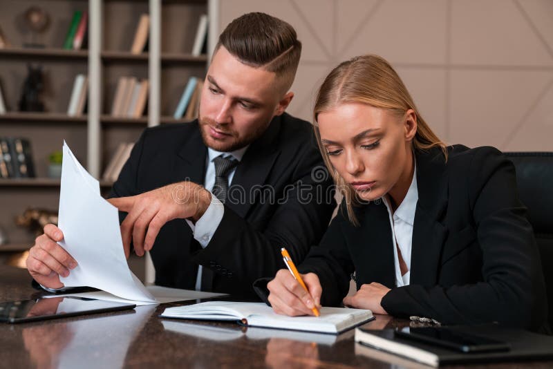 Serious businessman and businesswoman working together and taking notes royalty free stock image