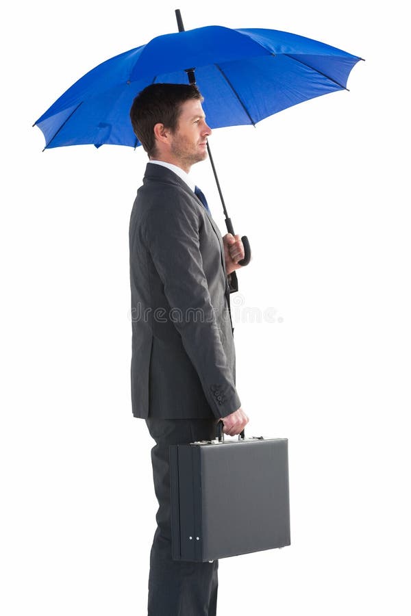 Serious businessman holding his umbrella and briefcase royalty free stock images Serious businessman holding his umbrella and briefcase royalty free stock images