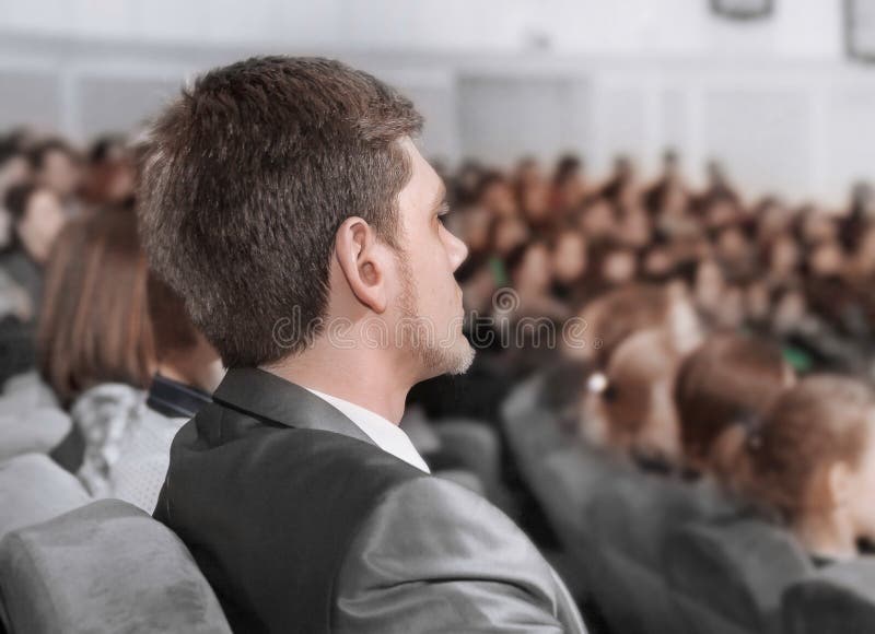 Serious businessman listening to a lecture in the conference hall stock image Serious businessman listening to a lecture in the conference hall stock image