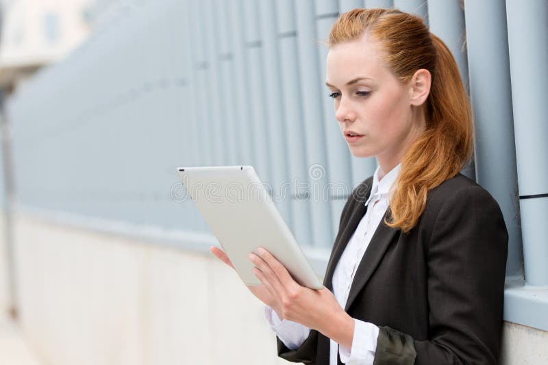 Serious Businesswoman Reading Tablet PC