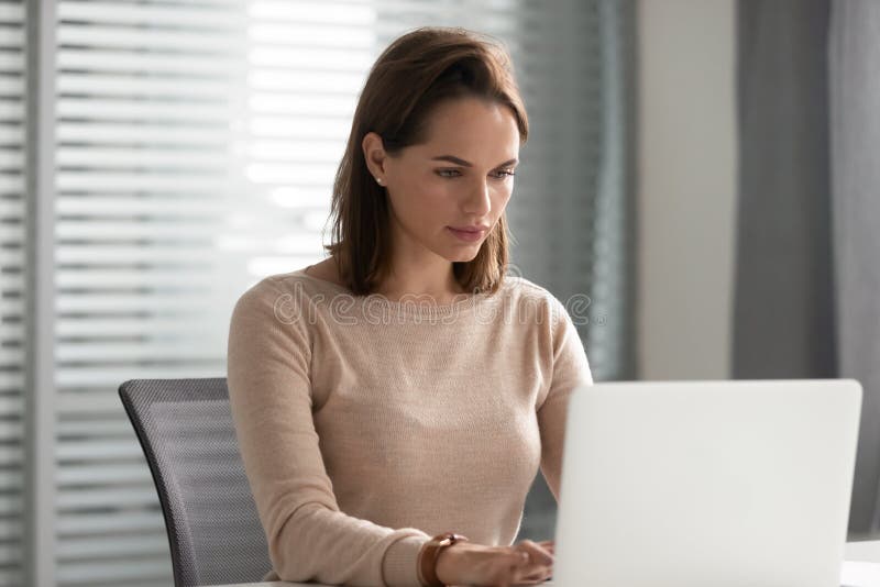 Serious businesswoman using laptop, looking at screen, working on project royalty free stock image Serious businesswoman using laptop, looking at screen, working on project royalty free stock image