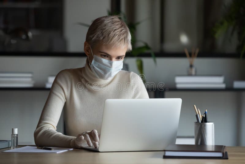 Female employee in medical protective gear work in office