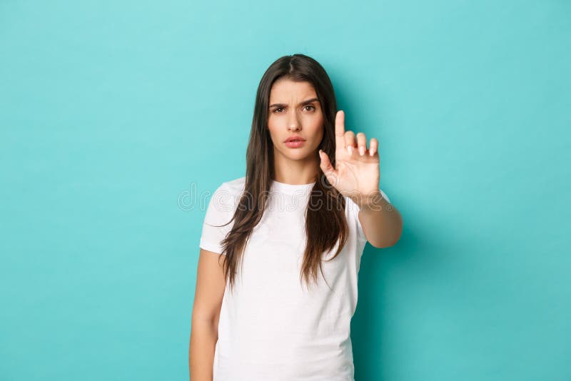 Serious and confident woman telling to stop, frowning and looking assertive, stretching one finger to scold or prohibit