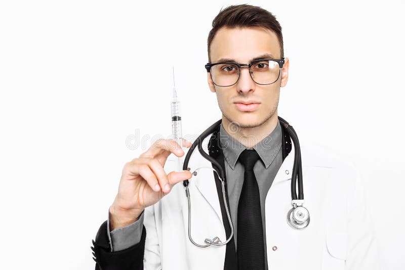 Serious doctor in glasses, with a stethoscope on his neck, holding a syringe for injection, isolated on a white background royalty free stock image Serious doctor in glasses, with a stethoscope on his neck, holding a syringe for injection, isolated on a white background royalty free stock image