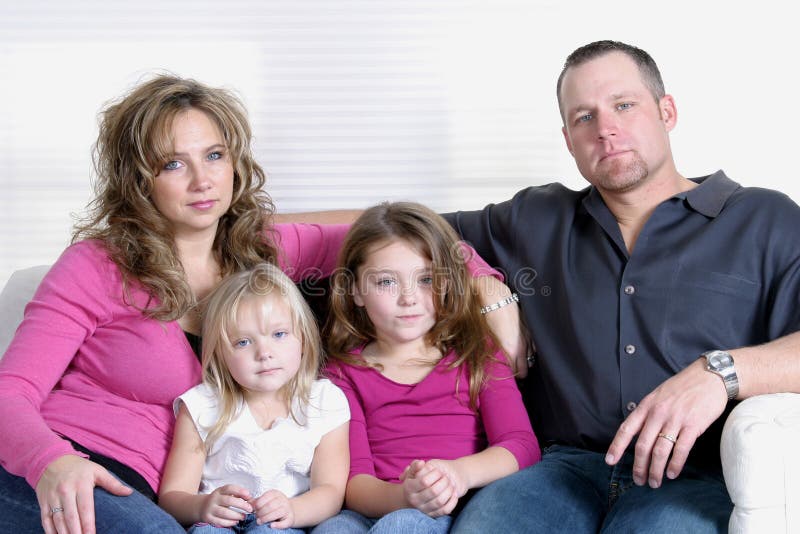Madre, padre e figlie seduto sul divano.