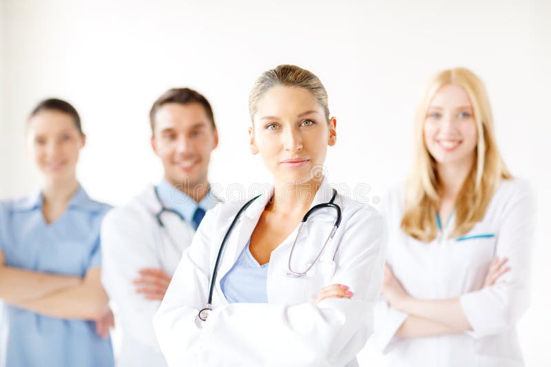 Serious female doctor in front of medical group royalty free stock photography Serious female doctor in front of medical group royalty free stock photography