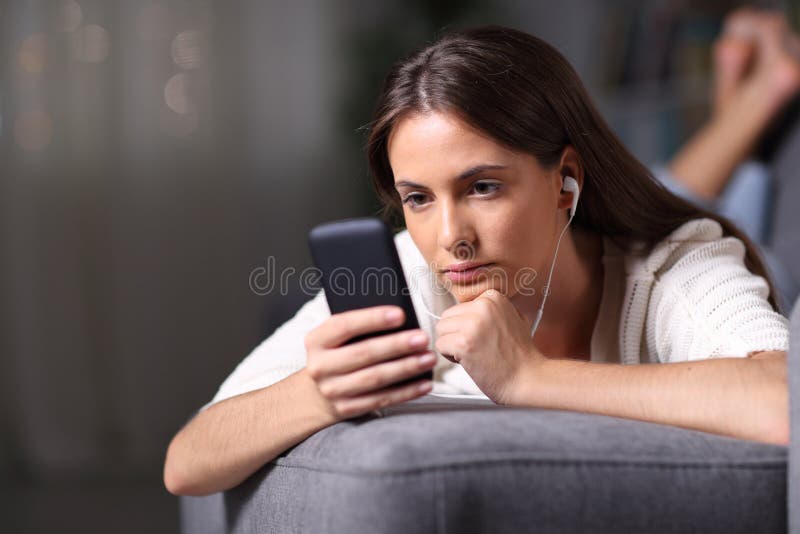 Serious girl listening to music reading phone content