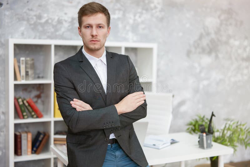 Serious handsome man manager standing in his office at his looking confident .bussiness, work concept