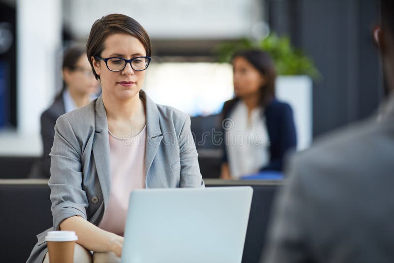 Serious lady analyzing sales report on laptop royalty free stock images Serious lady analyzing sales report on laptop royalty free stock images