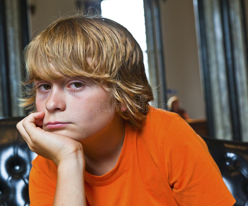 Serious looking boy sitting on a sofa