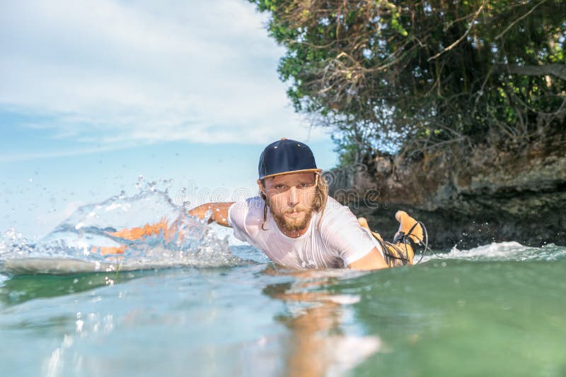 Serious Male Surfer Swimming on Surfing Board in Ocean at Nusa Dua