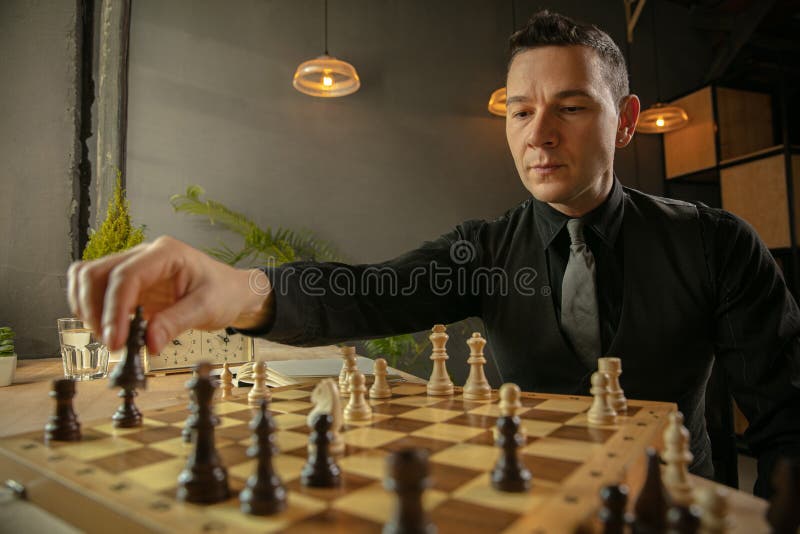 Serious man playing chess in studio · Free Stock Photo